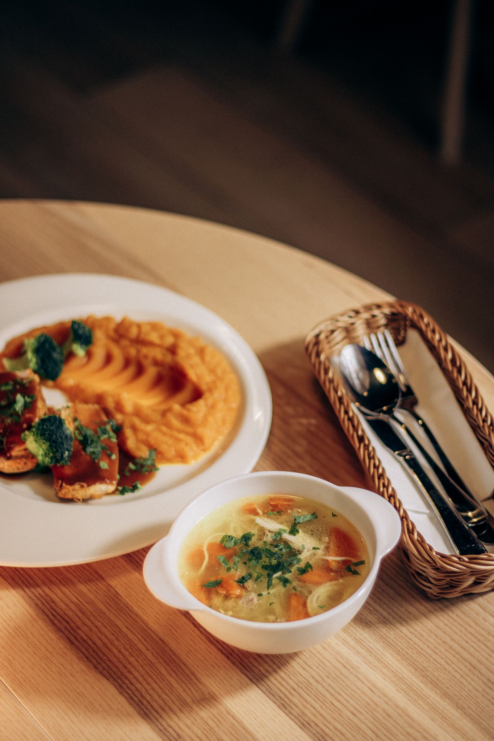 Puré de legumes e caldo servidos numa mesa de madeira